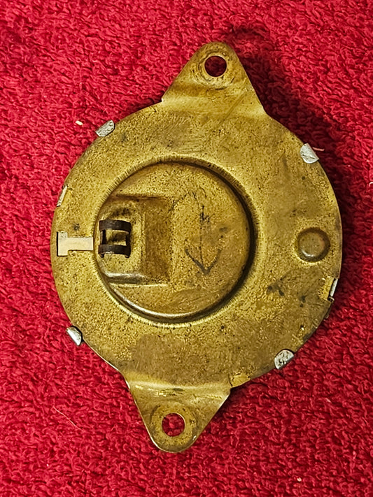 Reverse of Ford ammeter showing brass housing, two mounting ears and terminals