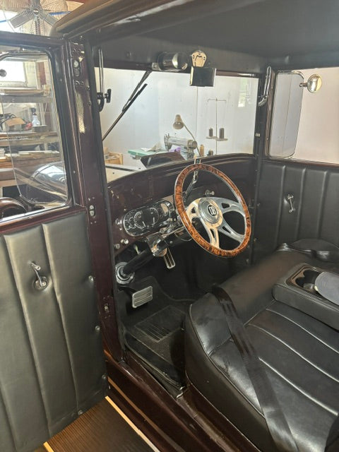 Interior from the passenger door - black pleated door panel, wood-rim steering wheel, round Dakota Digital gauges, floor shifter and console